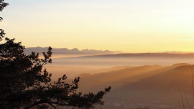 Paisagem montanhosa ao amanhecer, com névoa sobre os vales.