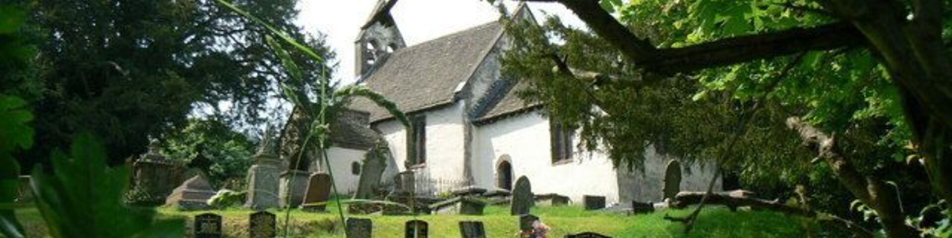 Una iglesia rodeada por un cementerio con lápidas.