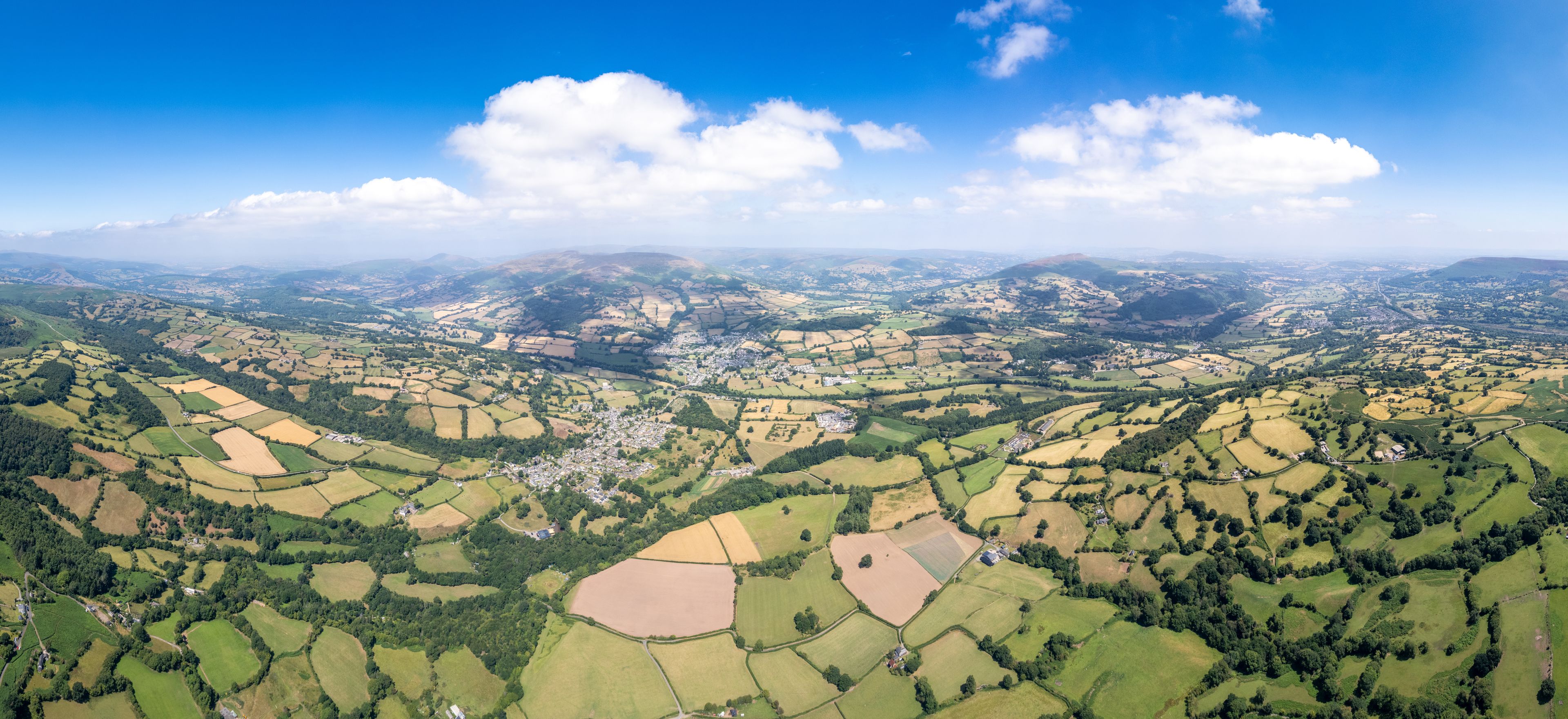 An aerial view of a valley with fields and a small town.
