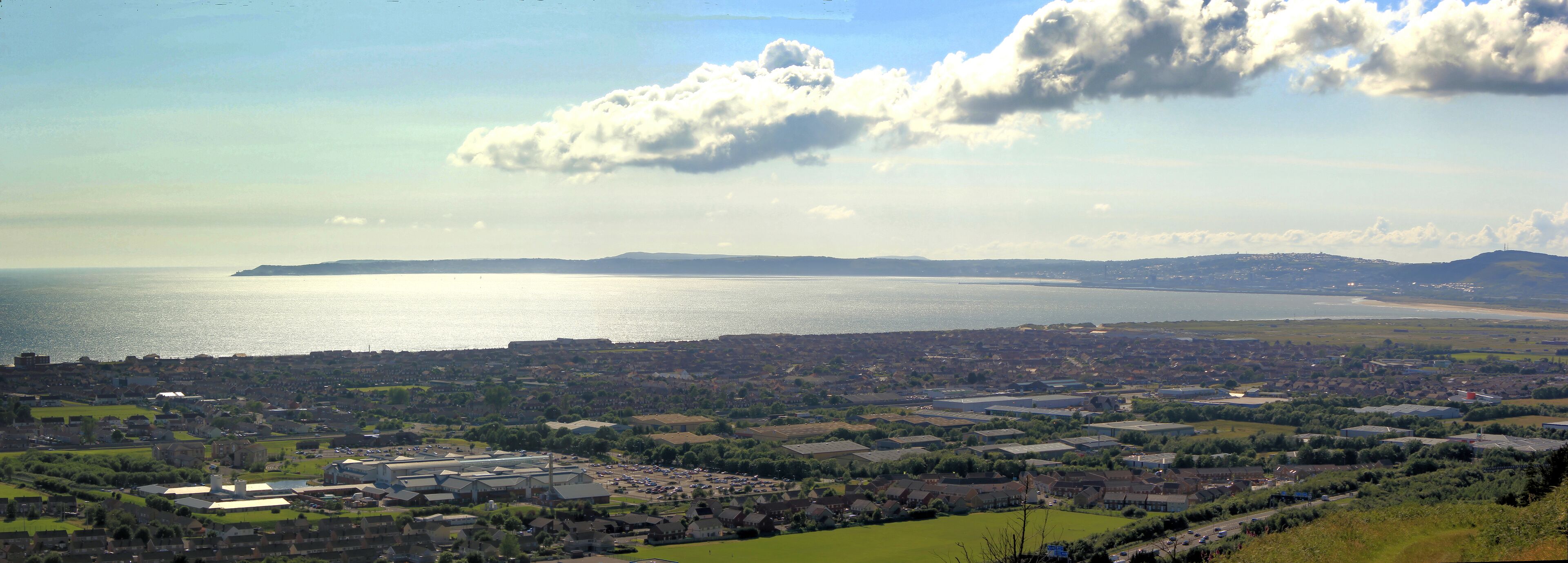 A coastal town with a large body of water, industrial buildings, and residential areas.