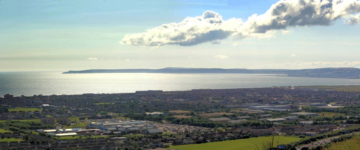 A coastal town with a large body of water, industrial buildings, and residential areas.