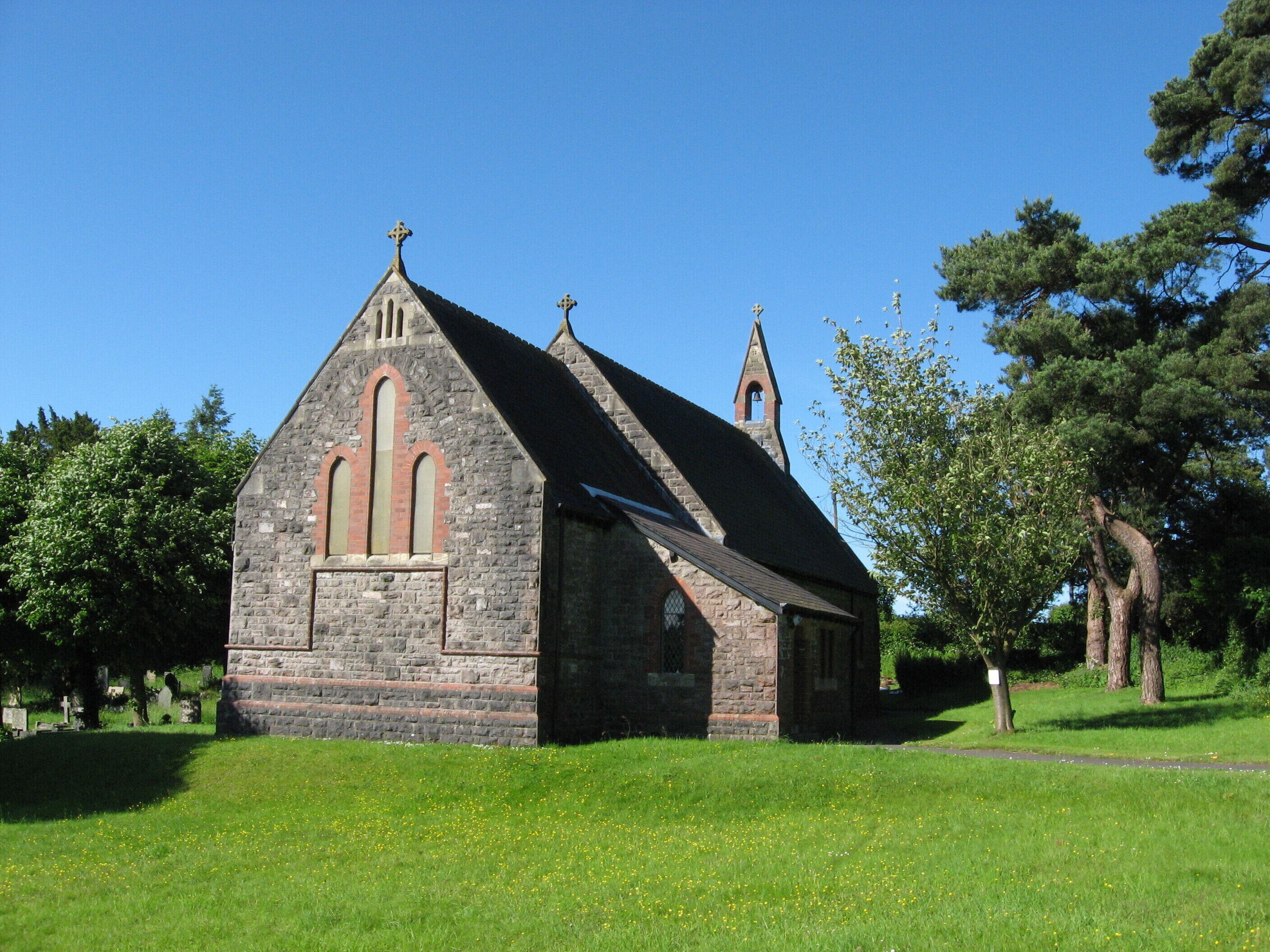 A stone church with a pointed roof and a bell tower.