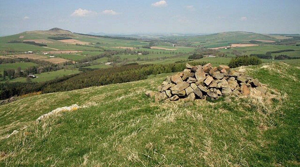 The summit of Bonchester Hill A small cairn marks the 323m summit of this prominent little hill overlooking the village of Bonchester Bridge. The summit is also the site of a fort and settlement. The hill on the far left is Rubers Law with Black Law on the far right.
