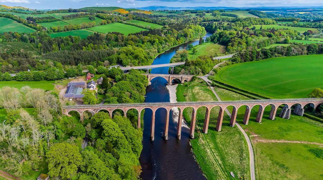 An aerial view of the Leaderfoot Viaduct, medieval bridge and modern road bridge in Scotland on a summers day
