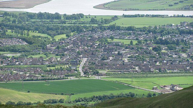 A town with a river, green fields, and scattered houses.