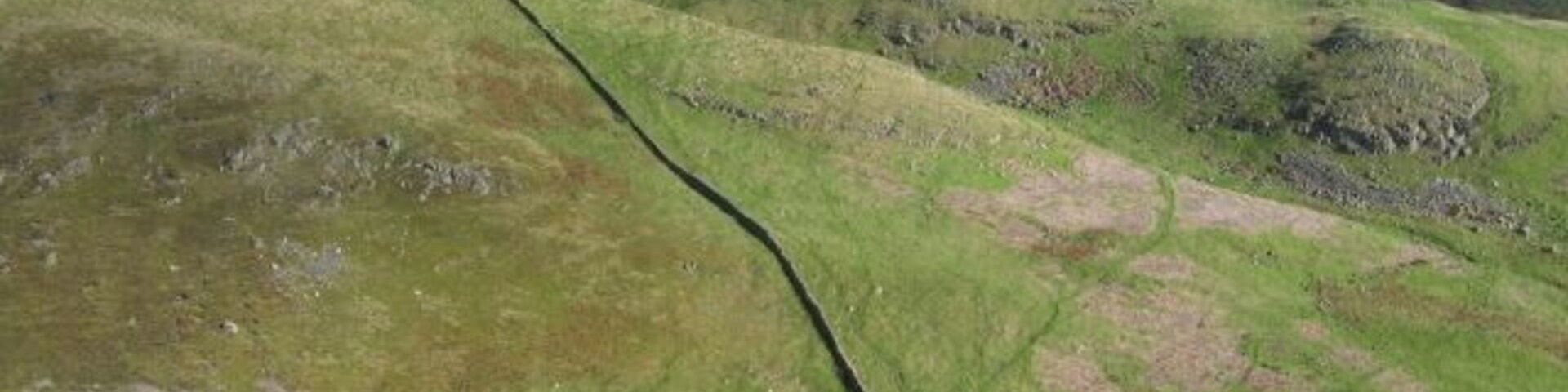 Colinas onduladas con un sendero estrecho que atraviesa el paisaje.