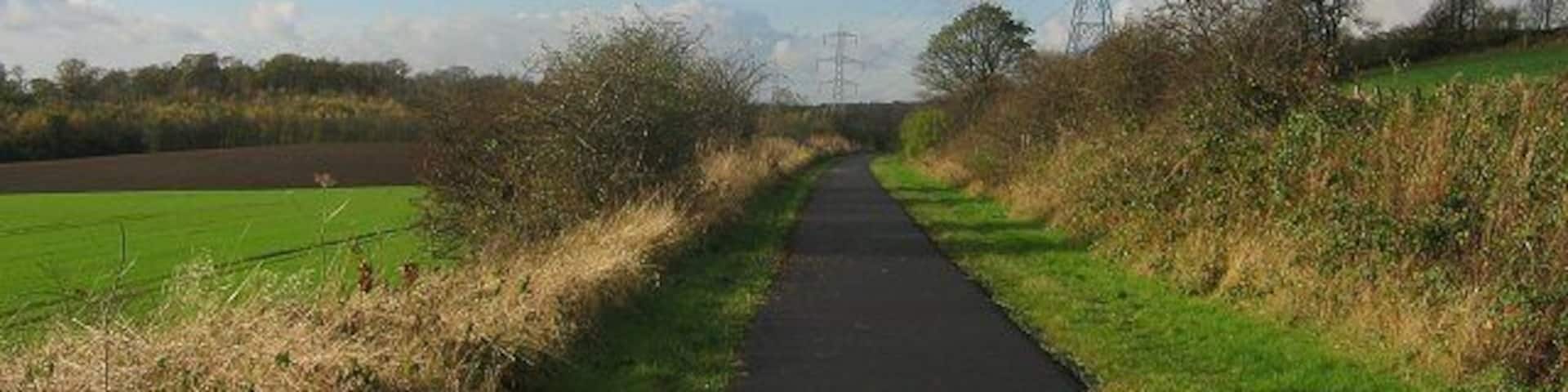 Dunfermline-Alloa railway. Now a cyclepath. Entering the square beneath Carneil Hill. Looking west.