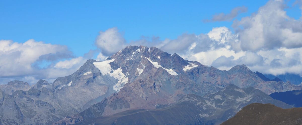 A mountain range with snow-capped peaks and a clear blue sky.