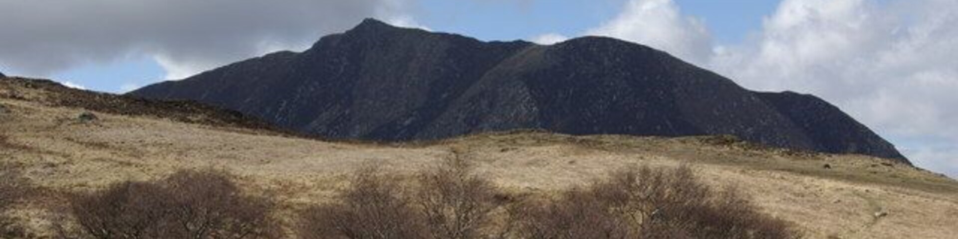 Una cordillera con vegetación escasa en primer plano.