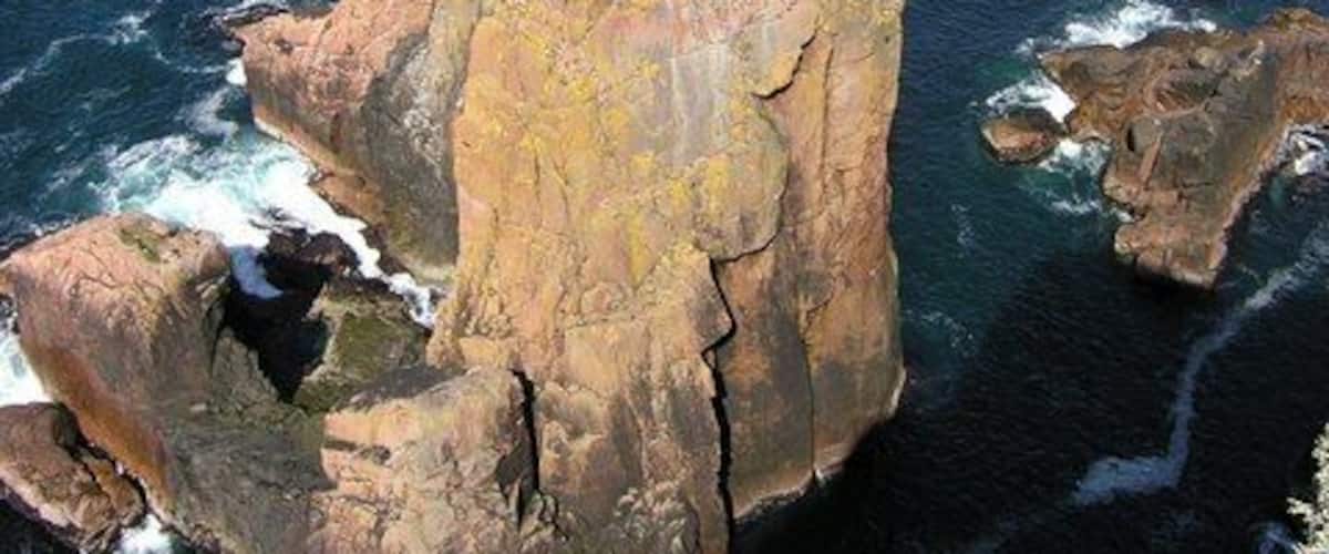 The Spindle, Muckle Roe The Spindle is another of the sandstone stacks that make up this part of the coast. The fine arch stack of Da Kist can be seen in the back ground.