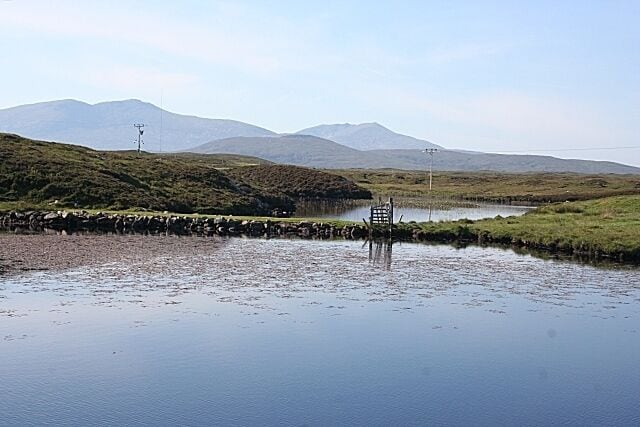 Loch a' Chnoic Bhric This looks like a causeway or wall across the narrowest part of the loch. Beyond are Thacla (Hecla) and Beinn Mhòr.