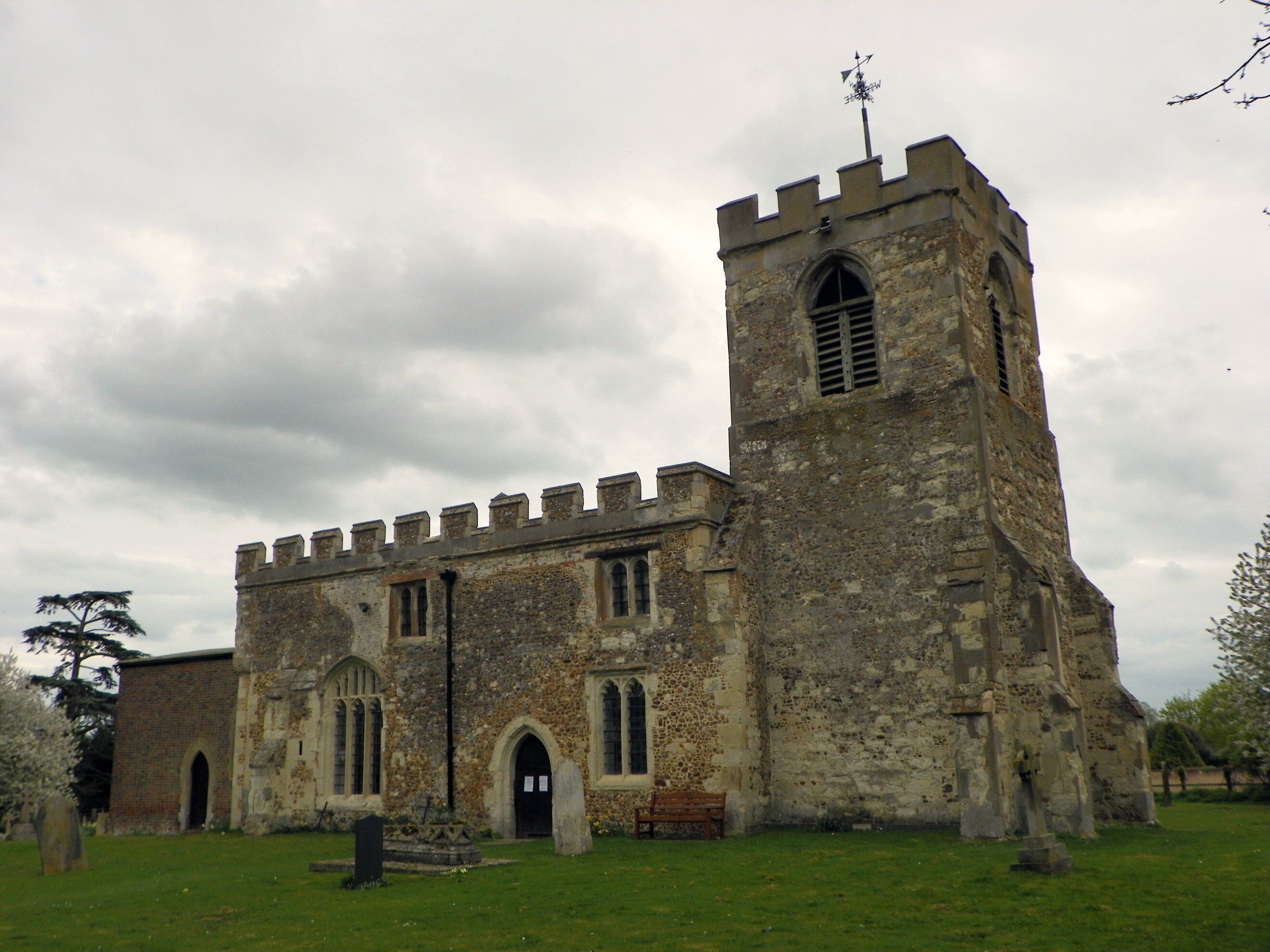 A historic stone church with a tall bell tower and arched windows.