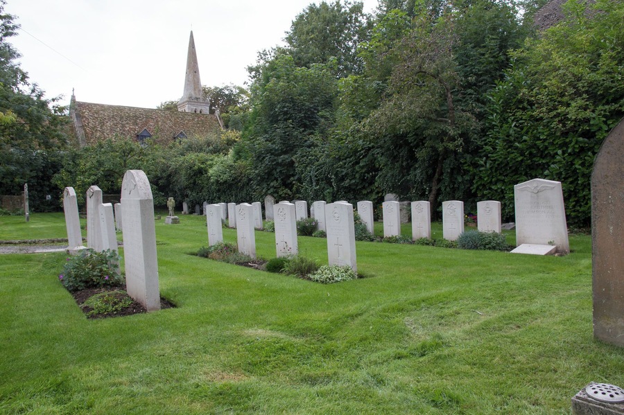 Commonwealth War Graves section of All Saints' parish churchyard, Wyton, Cambridgeshire (formerly Huntingdonshire), with the church beyond the hedge. The graves are of airmen from RAF Wyton.