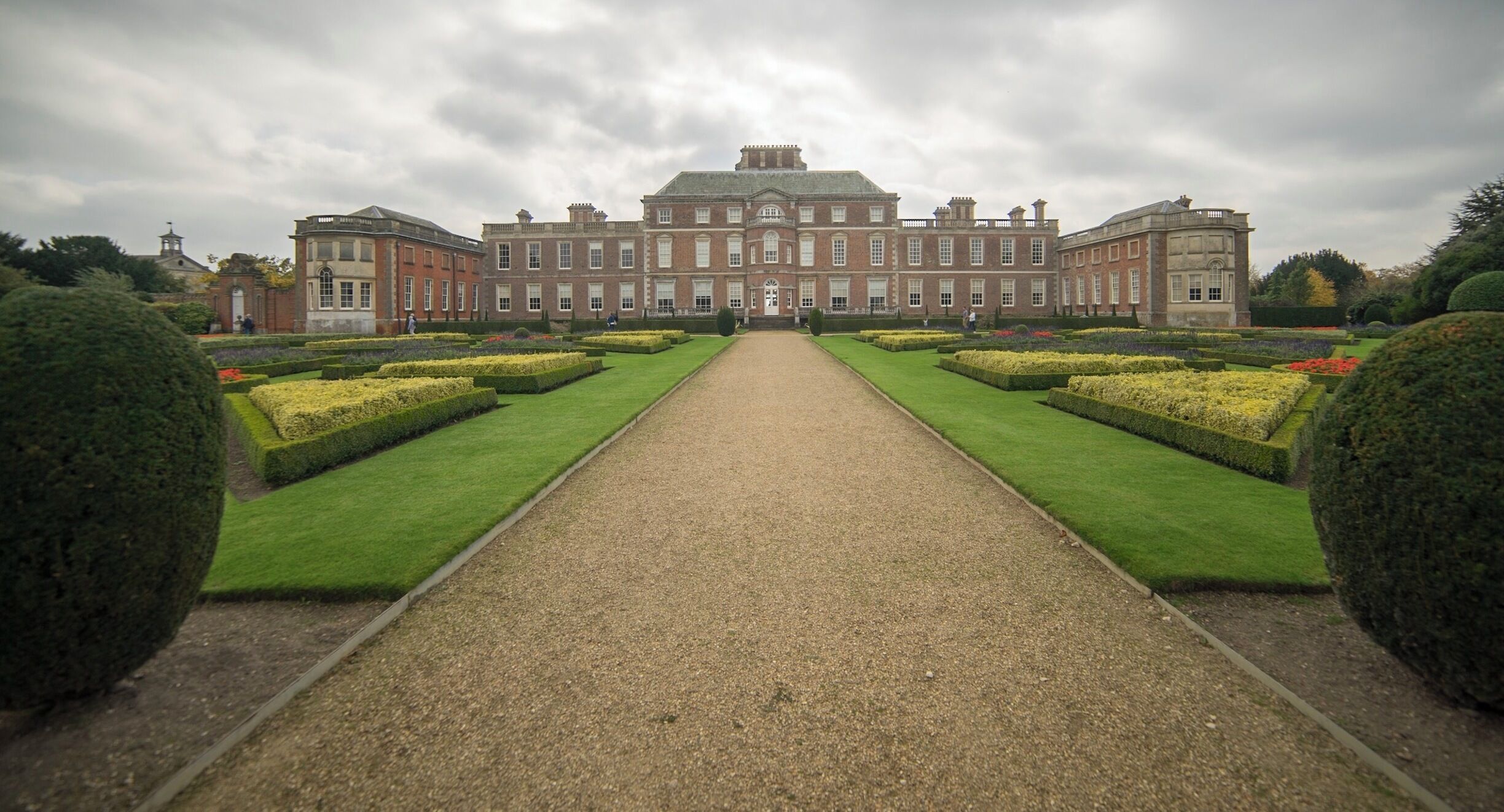 A large, symmetrical building with a central pathway leading to a grand entrance.