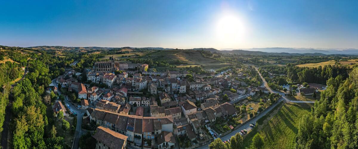 A town nestled in a valley with a prominent church and rolling hills in the background.