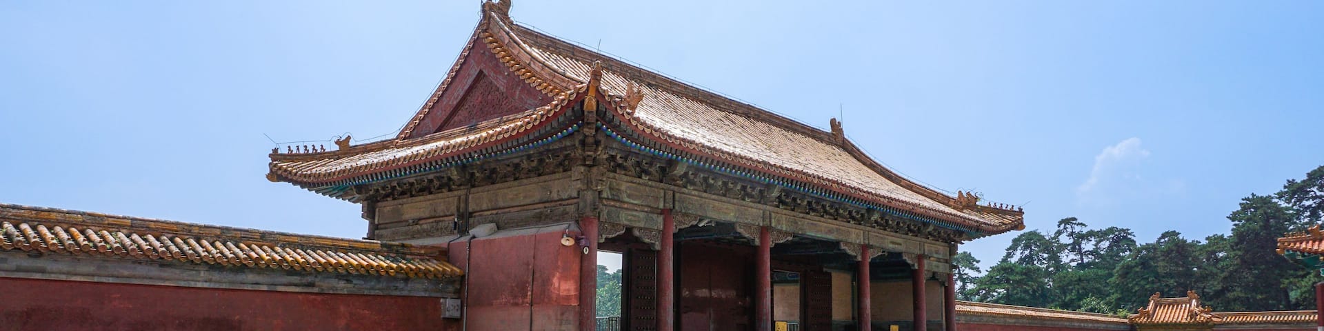 A traditional Chinese pavilion with ornate roof tiles and red walls.