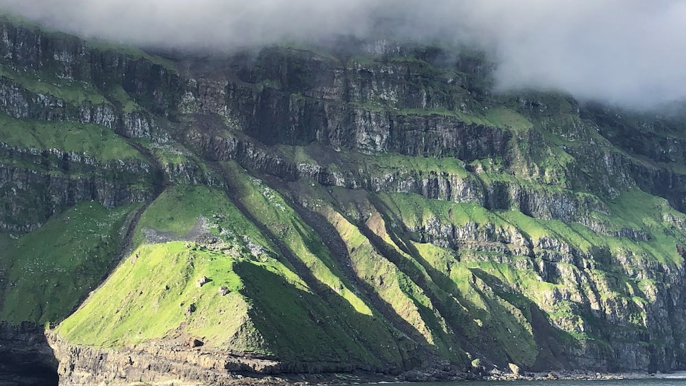 The cliffs of the island of Mykines in the Faroe Islands. Quite a view to and from the small harbor there.
