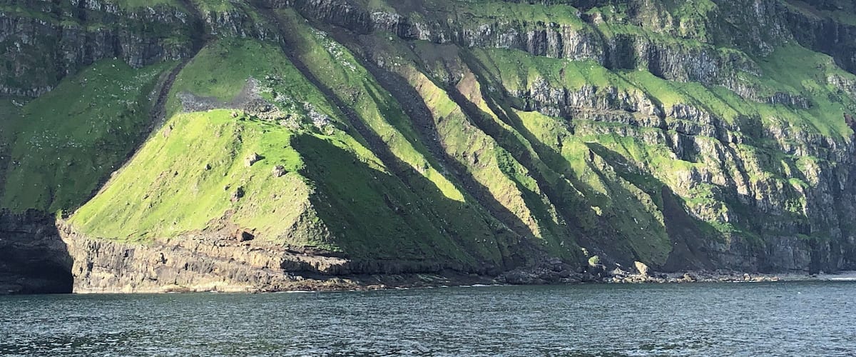 The cliffs of the island of Mykines in the Faroe Islands. Quite a view to and from the small harbor there.