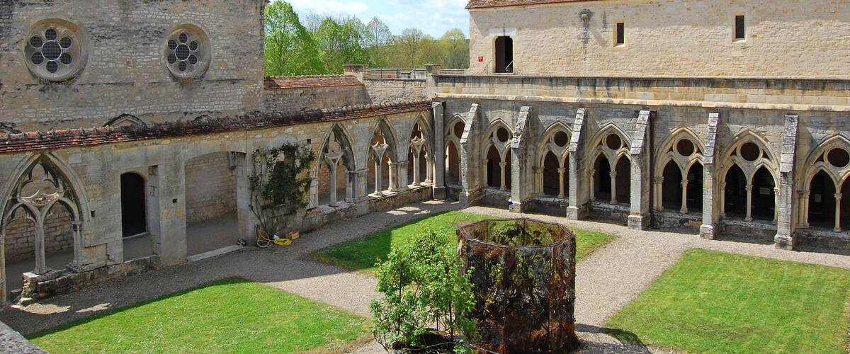 Un cloître historique doté d’arcs en pierre et d’une cour intérieure.