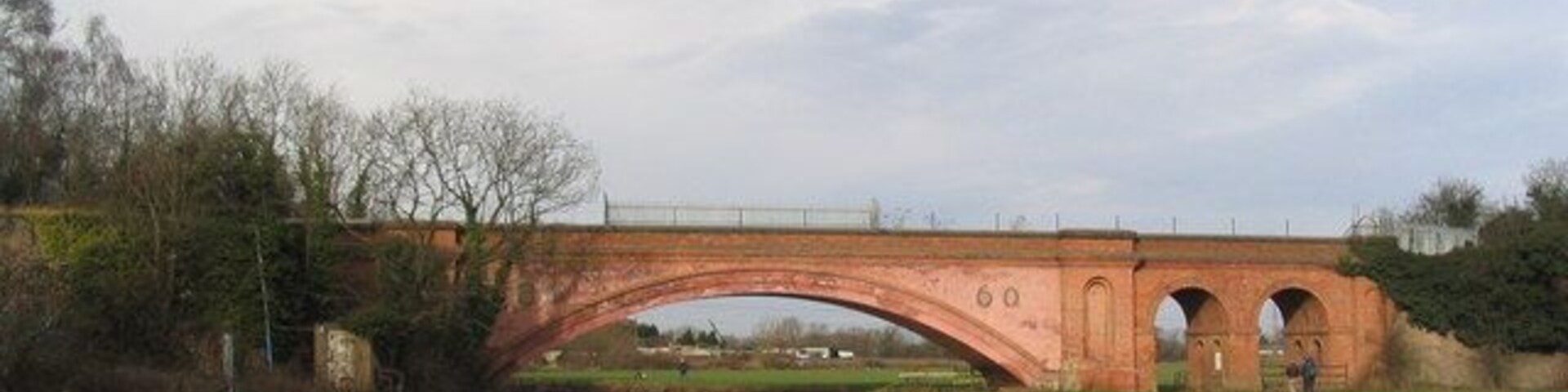 Victorian brick bridge over the Soar Has the date '1860' on it, and at the time was the largest brick span in Britain. The paler pink areas appear to be more recent cladding. The bridge used to carry rail trucks from the Mountsorrel granite quarries to the rail line at Barrow, but the granite chippings are now carried on a conveyor belt.
