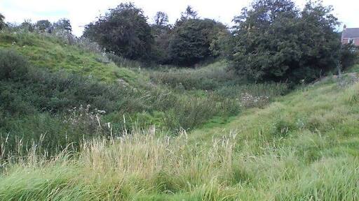 The Moat Surrounding Kirkby Fleetham motte, now somewhat overgrown and refilled, there is still evidence that the moat was stone-lined.