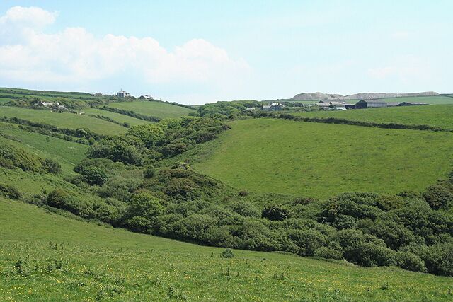 Tintagel: towards Trecarne Farm. The valley above Backways Cove turns south east below Trebarwith hamlet. Trecarne Farm, which had waterpower in the nineteenth century, is on the right, situated below the waste heaps of a quarry on Treligga Downs