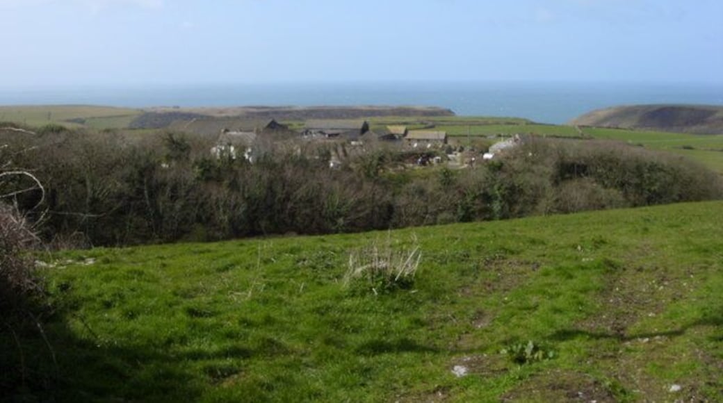 From Upton to Trecarne Farm Upton (behind photographer) is a farm converted to holiday cottages and also performs civil marriages. Trecarne Farm (centre) still has its dairy herd and its road runs in from the left along a stream at the bottom of the wooded valley. These farms are south of Trebarwith Strand and in Tintagel parish.