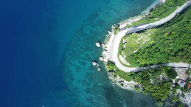 Aerial shot of the shore in Negros Oriental, Philippines, with the daylight reflection in the water