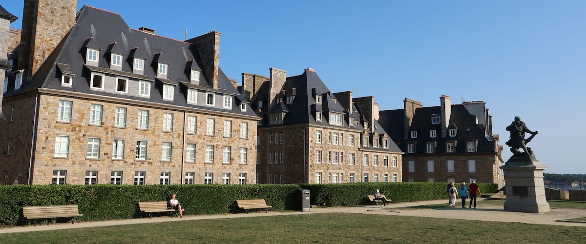 Bastion de la Hollande, place bordée d’immeubles, avec une pelouse, sur les remparts de la ville de Saint-Malo intra-muros, en Bretagne (France)
