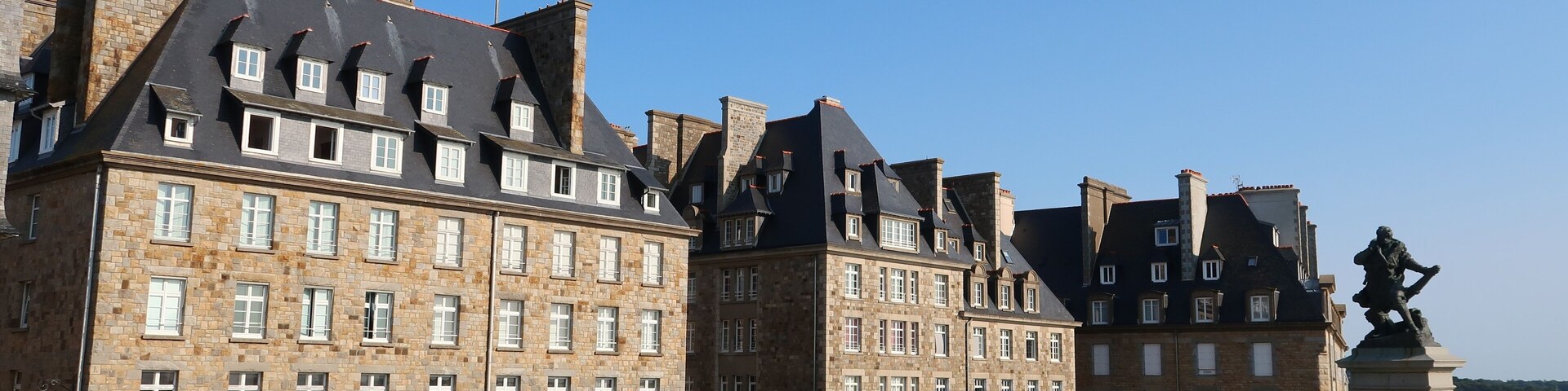 Bastion de la Hollande, place bordée d’immeubles, avec une pelouse, sur les remparts de la ville de Saint-Malo intra-muros, en Bretagne (France)