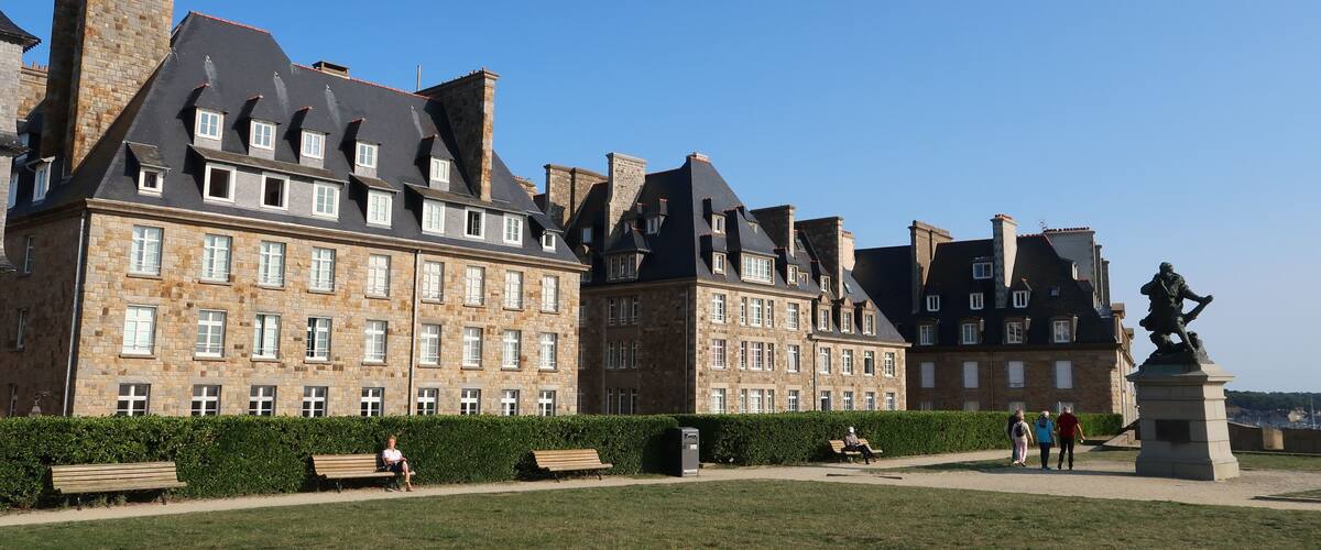 A historic building with stone facades and multiple chimneys.