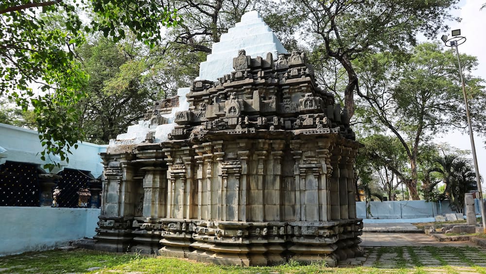 Un temple en pierre orné de sculptures complexes et surmonté d’une flèche blanche.