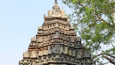 A detailed stone temple with intricate carvings and a tiered structure.