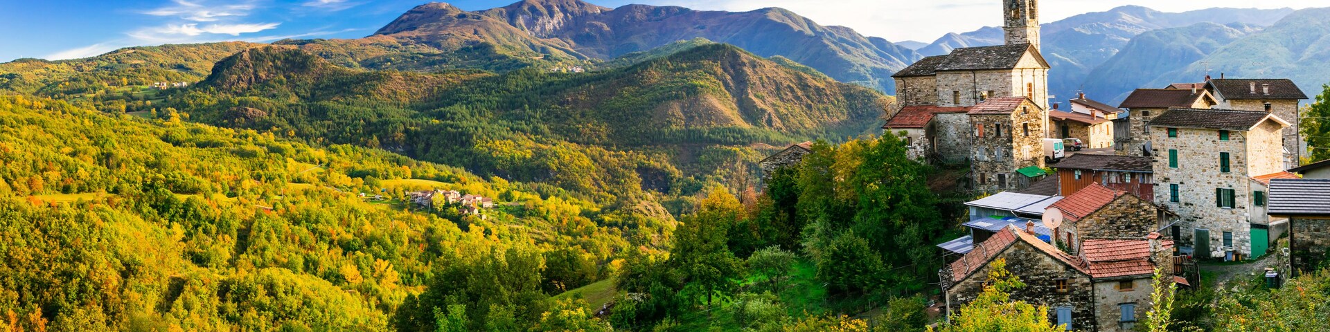 Un paisaje montañoso con una iglesia y edificios de piedra tradicionales.