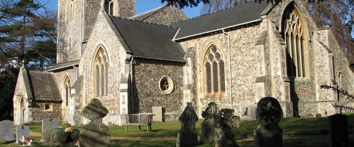 A stone church with a tall tower and arched windows.