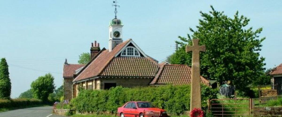 War Memorial at Ingleby Cross There is an interesting clock and weather vane on the building behind.