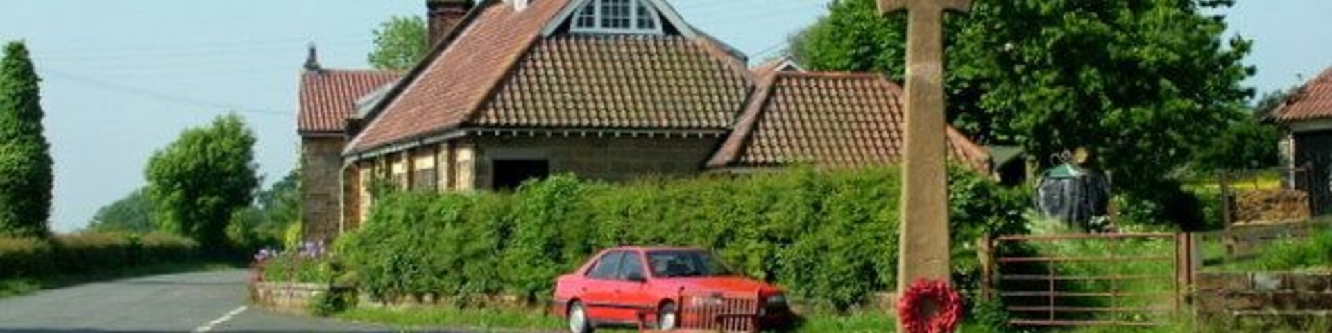 War Memorial at Ingleby Cross There is an interesting clock and weather vane on the building behind.