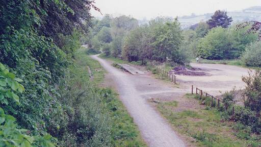 Dudbridge station (remains), 1990. View westward, towards Stonehouse: ex-Midland Stonehouse - Nailsworth branch, junction of branch to Stroud (Midland). The station and both branches were closed to passengers 16/6/47, to goods 1/6/66