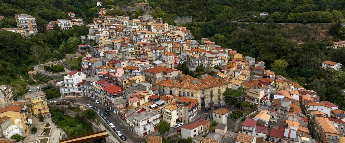 A densely packed hillside town with terracotta-roofed buildings and narrow streets.