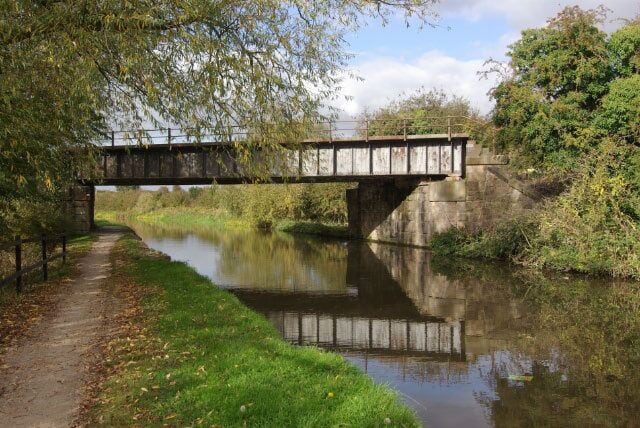 Railway bridge at Swarkestone. The bridge carrying the Stenson Junction - Sheet Stores Junction railway over the Trent & Mersey Canal basks in a burst of autumn sunshine. This railway crosses the canal twice; this is the westernmost bridge.