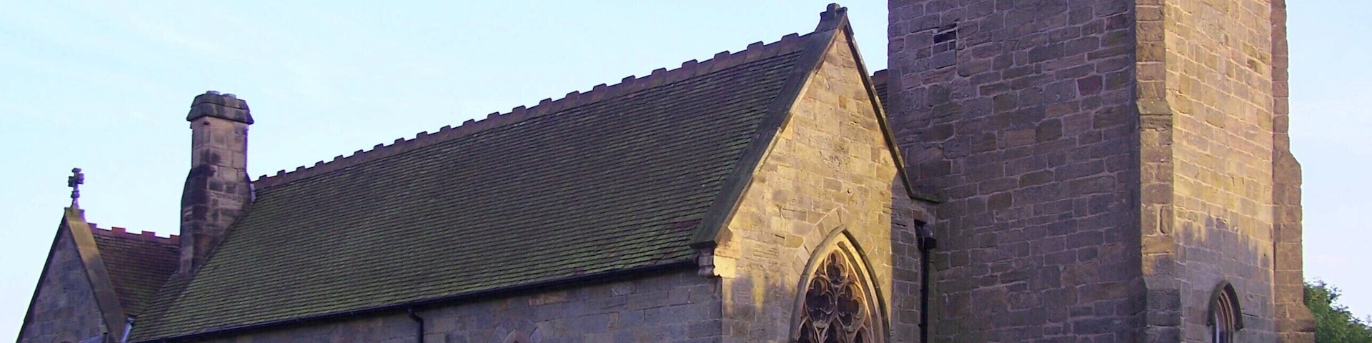 Eine historische Kirche mit hohem Turm und traditioneller Stein-Fassade.