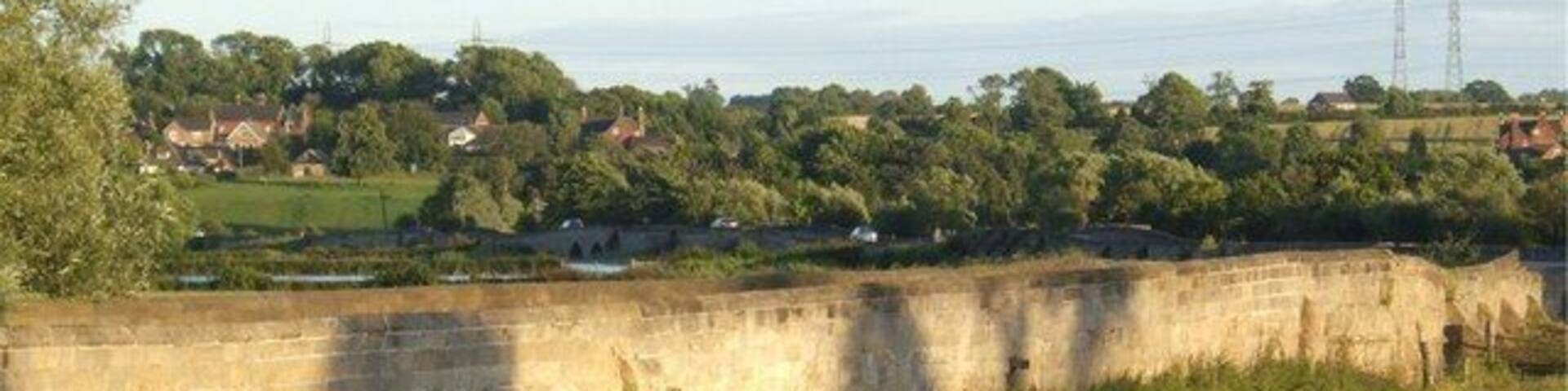Swarkestone Causeway Swarkestone Causeway is a grade-1 listed structure dating from the 13th century. It was built to cross marshy ground in the flood plain of the River Trent. The name Trent is thought to mean "trespasser", i.e. river liable to flood. The land still floods regularly in bad weather. The river itself is crossed by an 18th century hump-backed bridge, built when this section of the river was navigable.