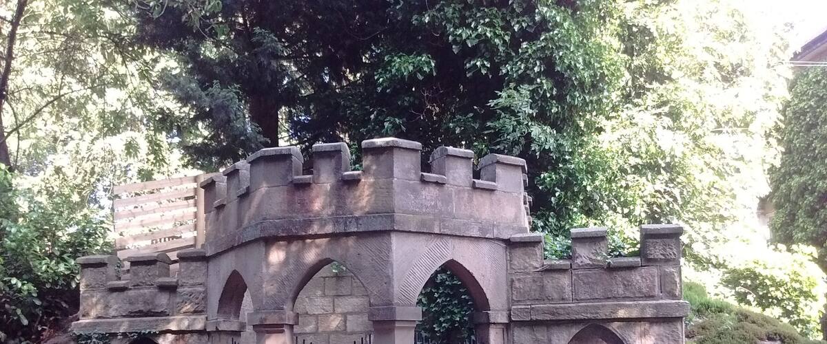 A stone castle-like structure with arched windows and a gated entrance.