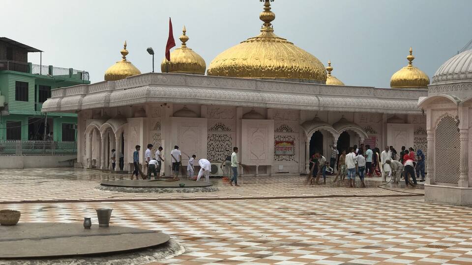 A courtyard with a checkered floor and golden domes.