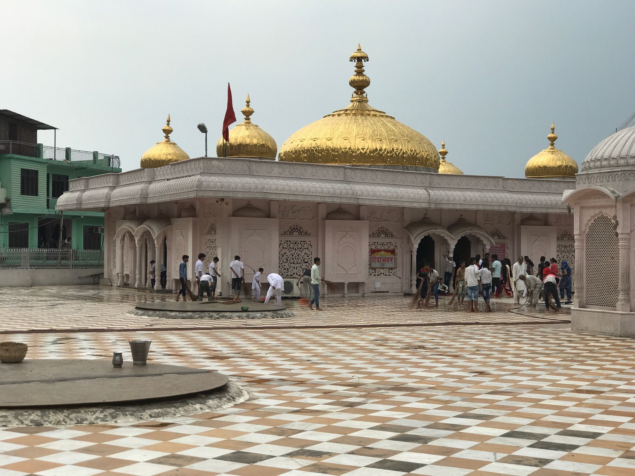 A courtyard with a checkered floor and golden domes.
