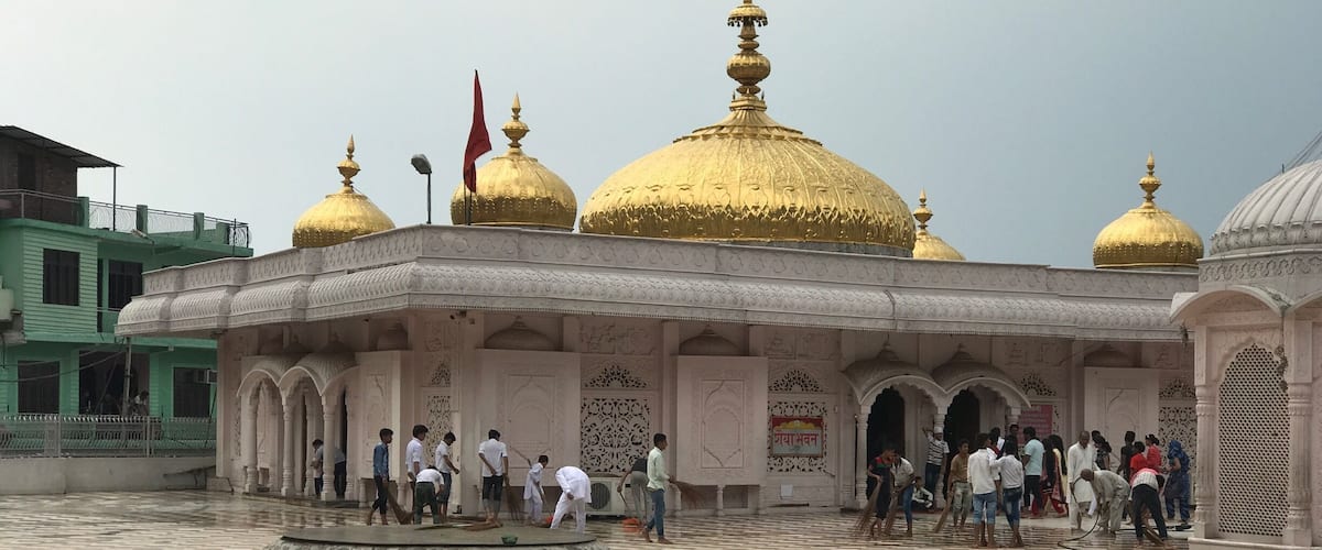 A courtyard with a checkered floor and golden domes.