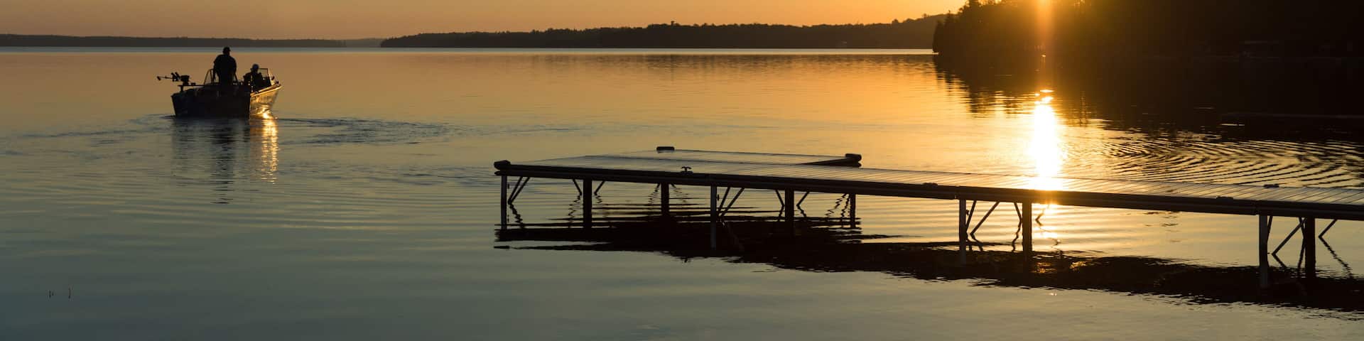 Cottage Life - Father and son fishing on a boat at sunrise/sunset at the peaceful cottage in Kawartha Lakes Ontario Canada on Balsam Lake