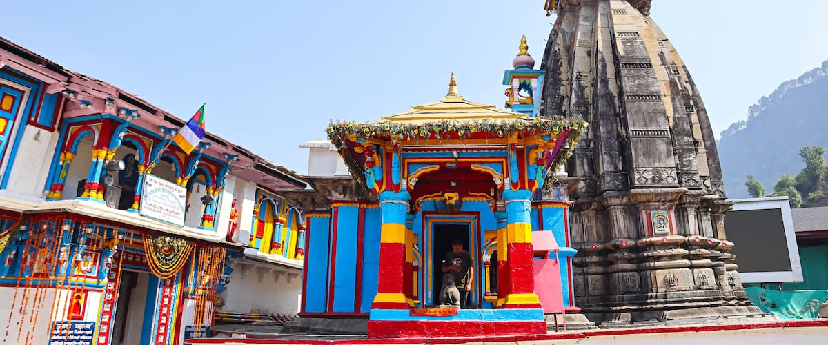 A colorful temple with a golden spire and a stone structure.