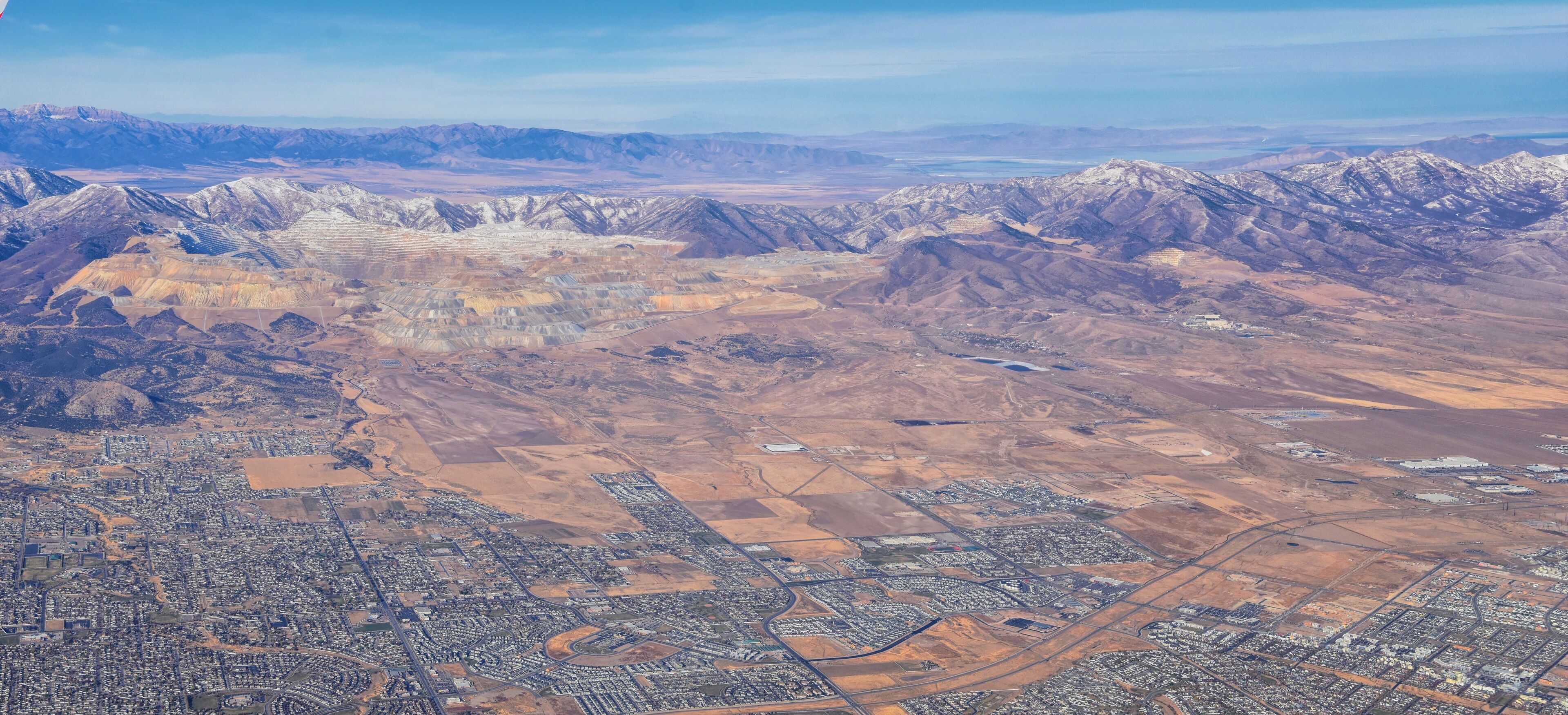 An aerial view of a city with surrounding mountains and a desert landscape.