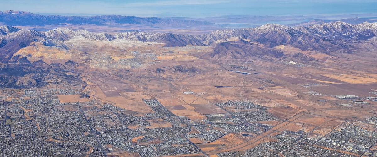 An aerial view of a city with surrounding mountains and a desert landscape.